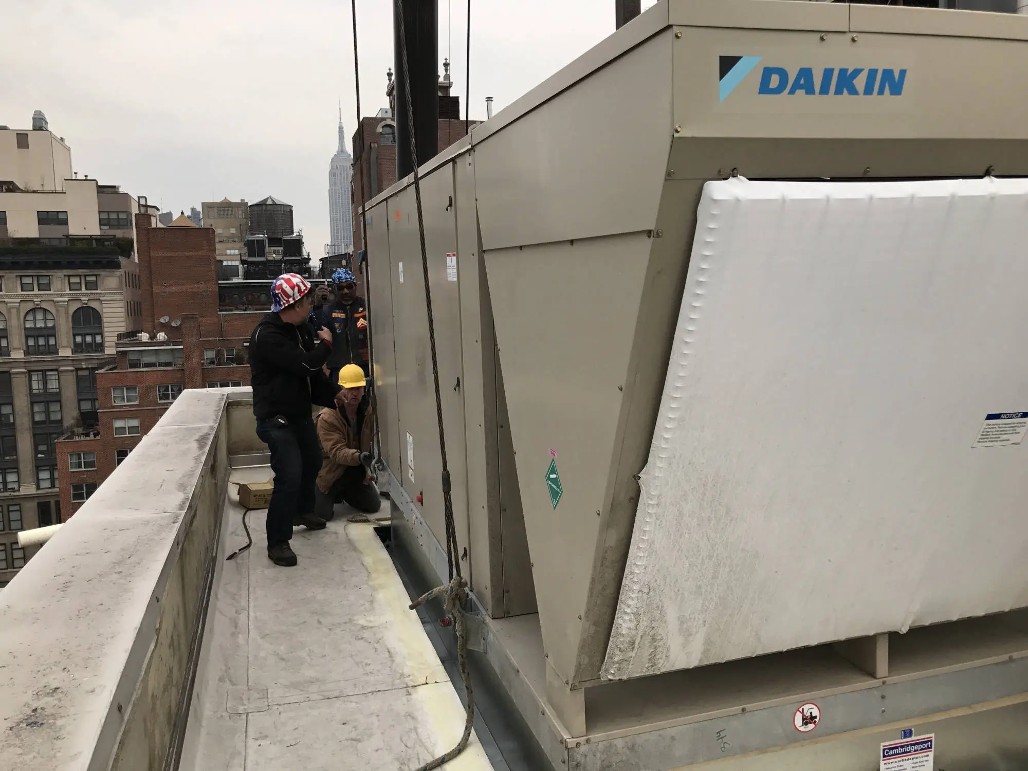 HVAC team on rooftop in Manhattan working on Daikin unit installation