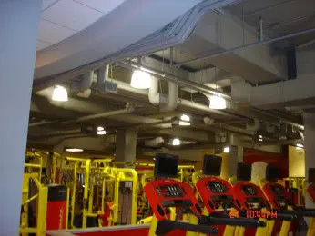 Exposed HVAC ductwork above cardio machines at Retro Gym in Yonkers, NY