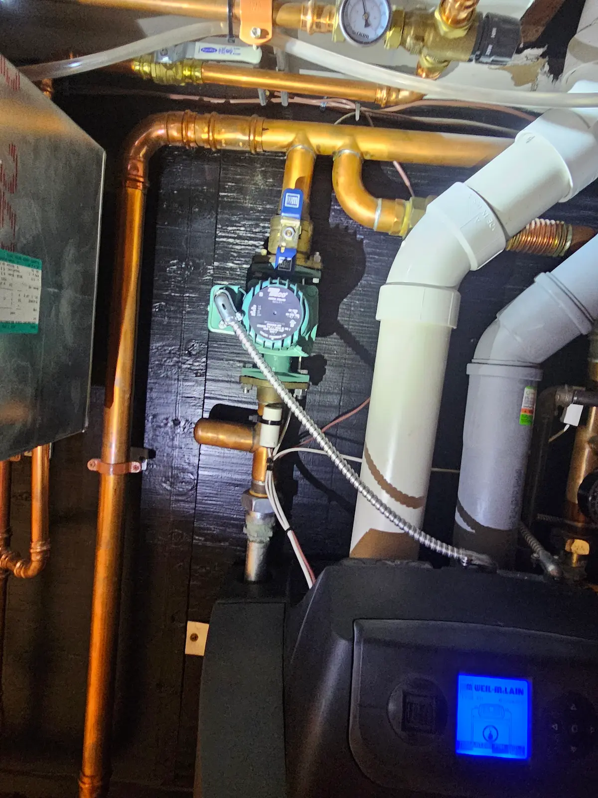 Residential hydronic boiler system with newly installed Taco 0014 circulator pump, copper piping, and heating components during boiler repair service in Larchmont, NY