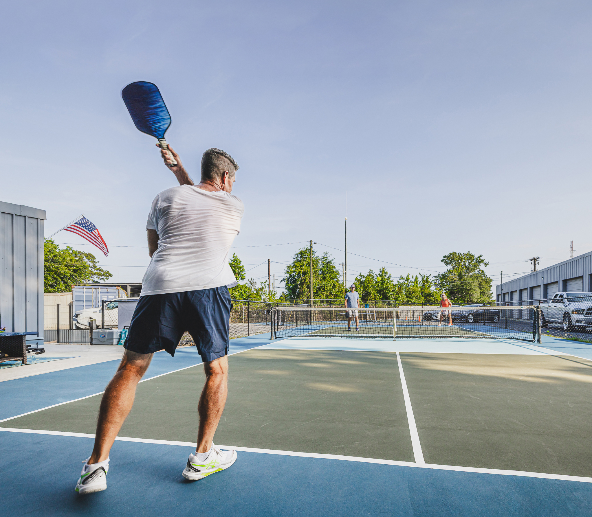 3 people playing pickleball