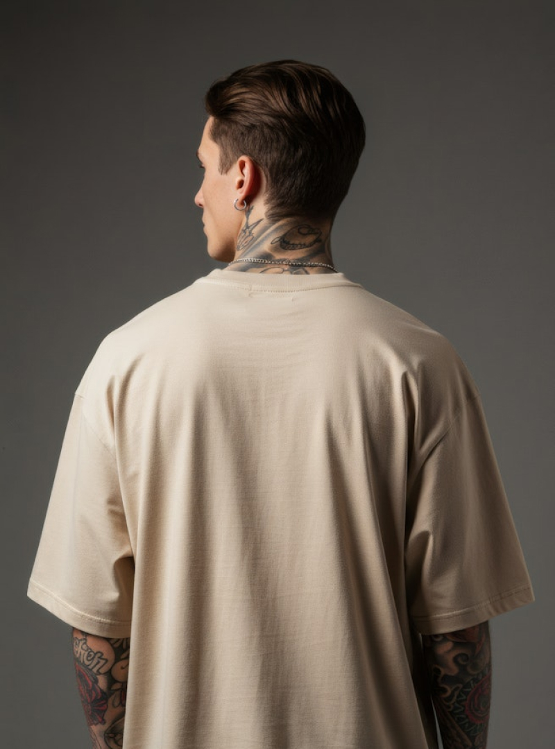 A man with a tattoo on his neck wearing a beige shirt.