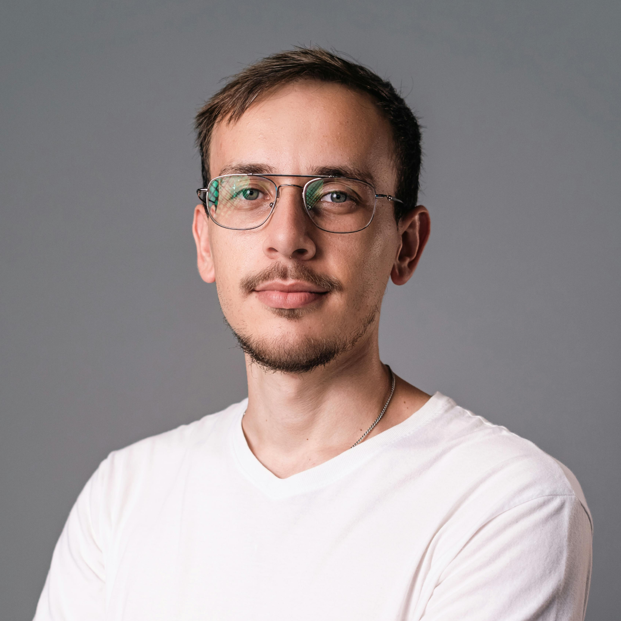 A man wearing glasses and a white shirt.