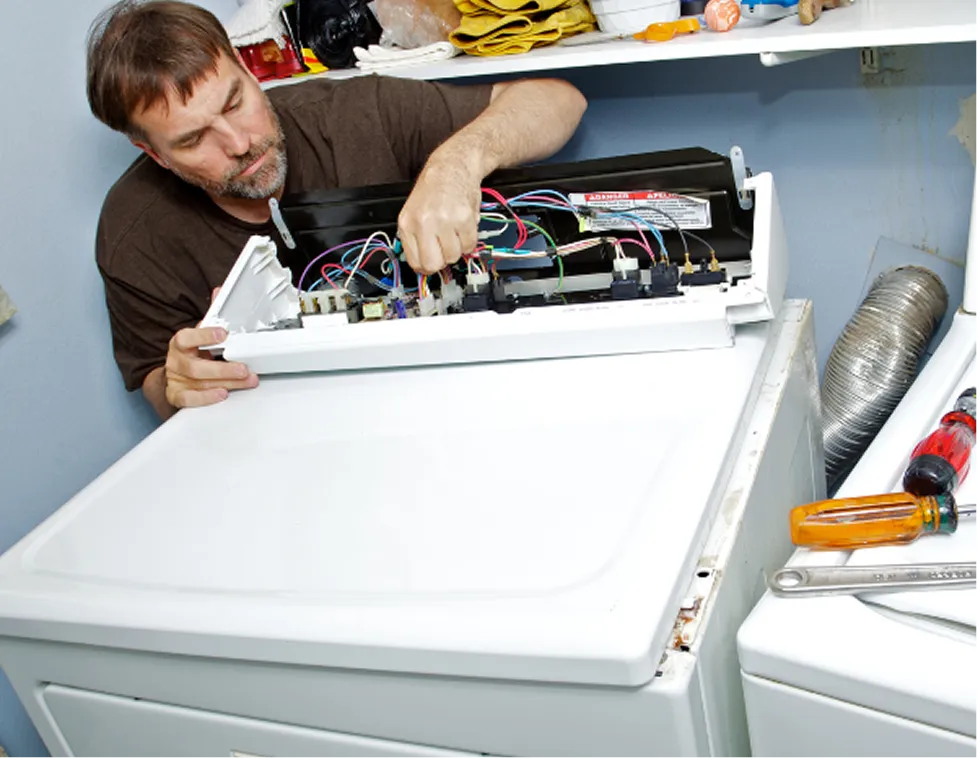 Technicin in a process of repairing a dryer