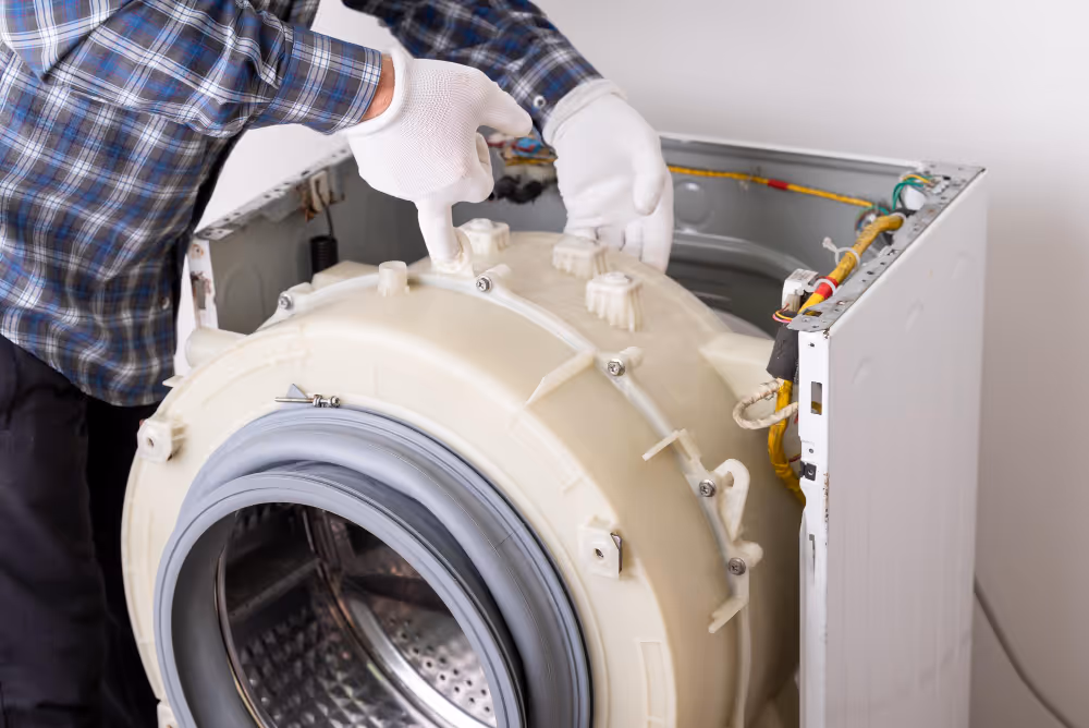 Technician repairing internal parts of front load washing machine