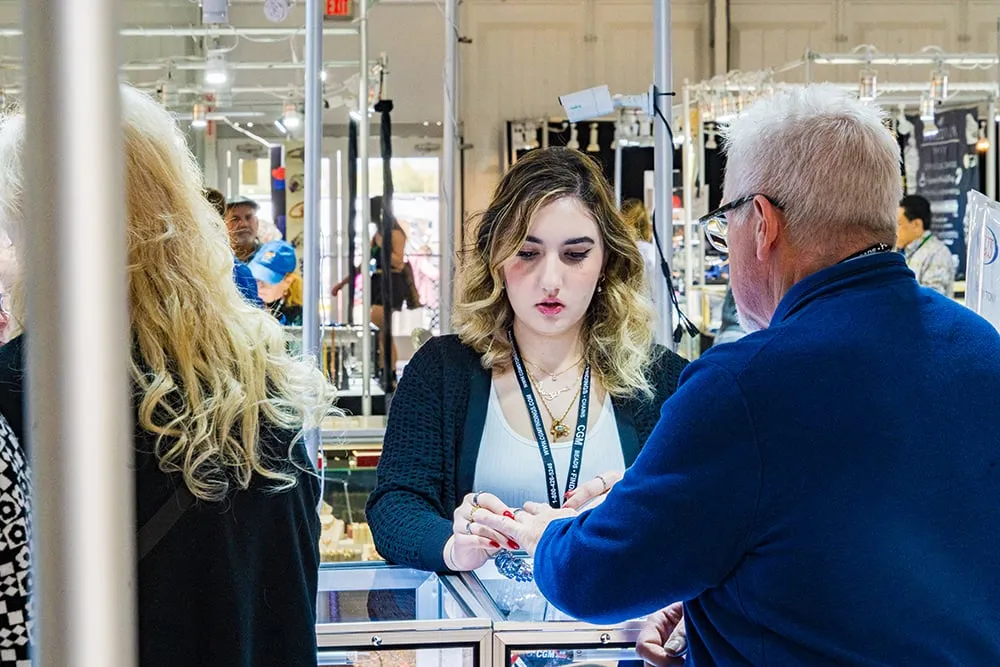 Exhibitor consulting with wholesale buyer at Tucson Gem Show booth