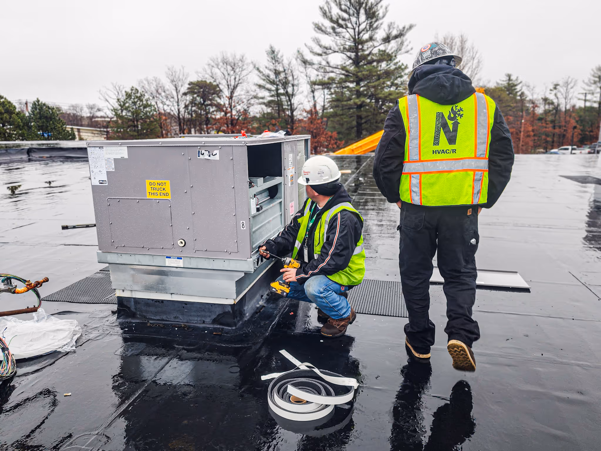 Northstar technicians in safety gear servicing a rooftop unit