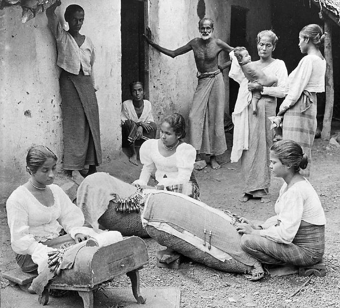 Women in Sri Lanka making traditional Beeralu bobbin lace, surrounded by villagers.