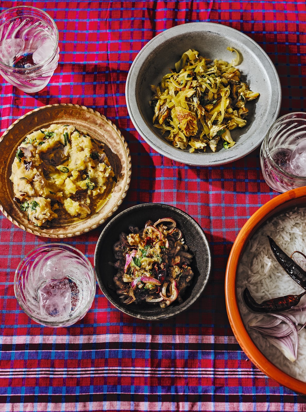 4 Bangladeshi dishes on a checkered table cloth viewed from the top.