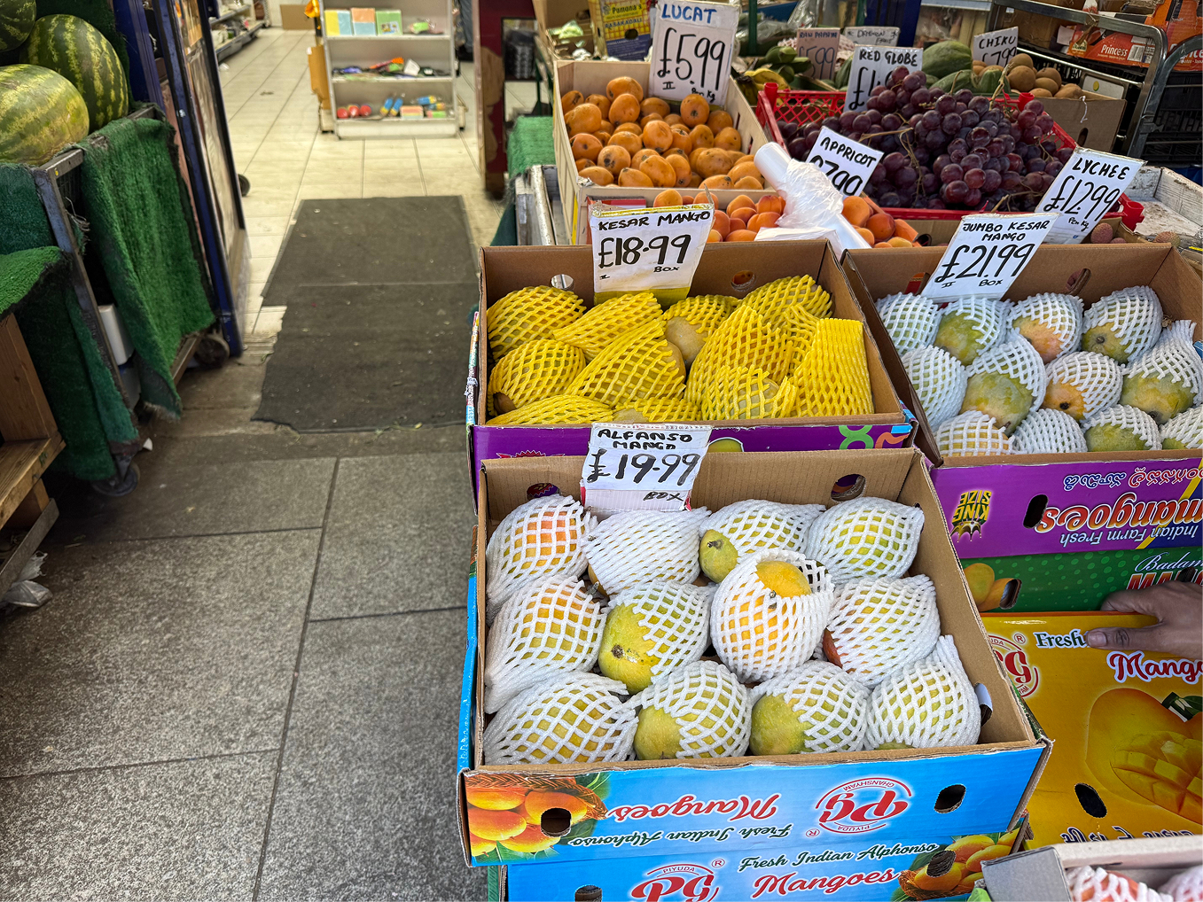 A box of mangoes is priced at 19.90 pounds in front of a shop in Southall, London