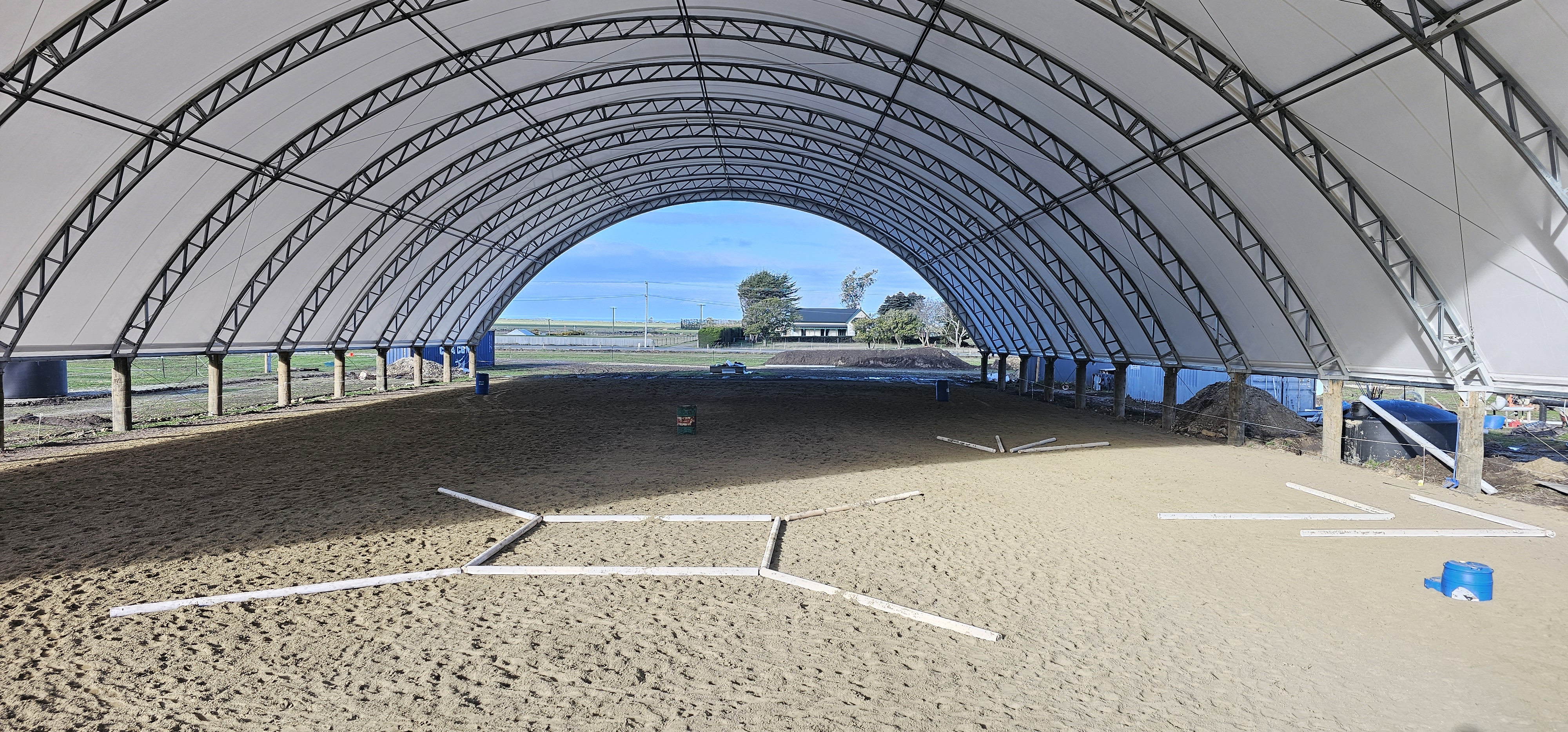 Inside of a Horse Arena with a TortoShelter over the top