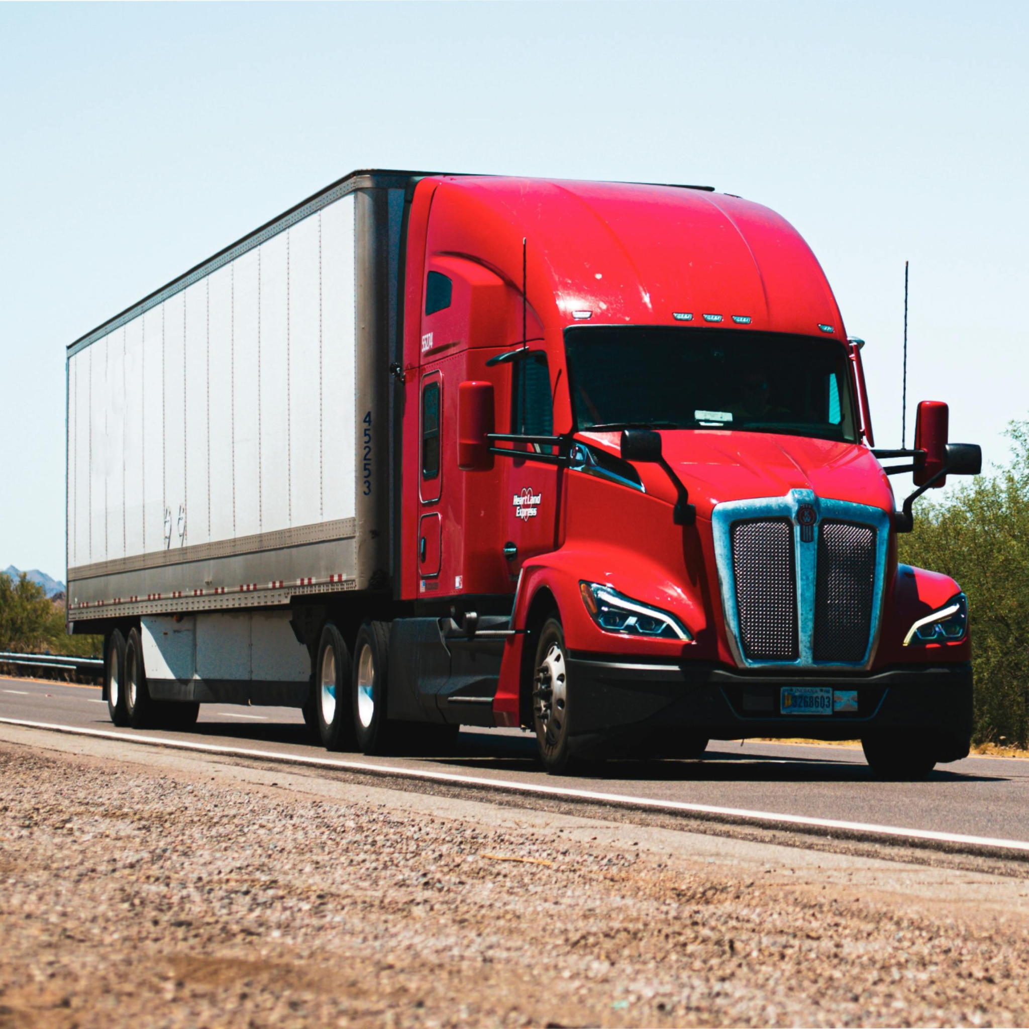 Large red tractor trailer on a highway depicting our commercial trucking policies 