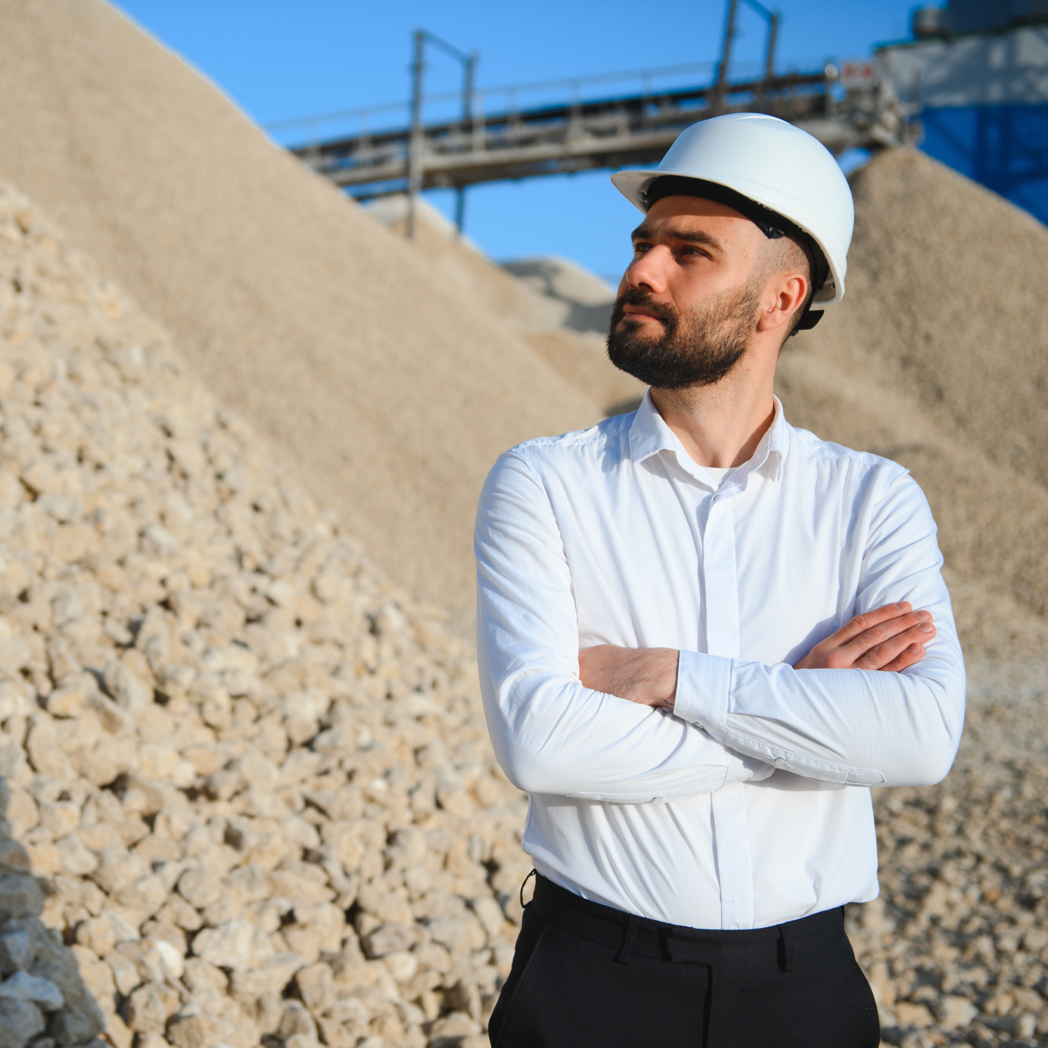 male contractor in front of large gravel pile 