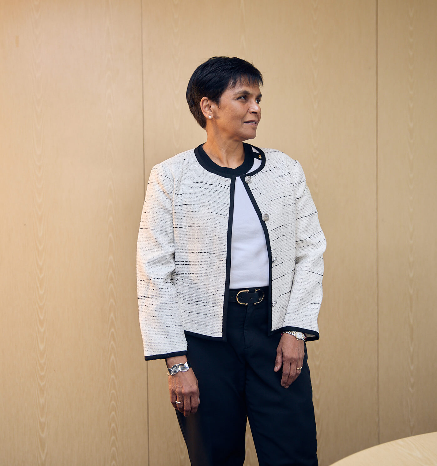A portrait of Delphine Cassidy standing in a boardroom looking off camera
