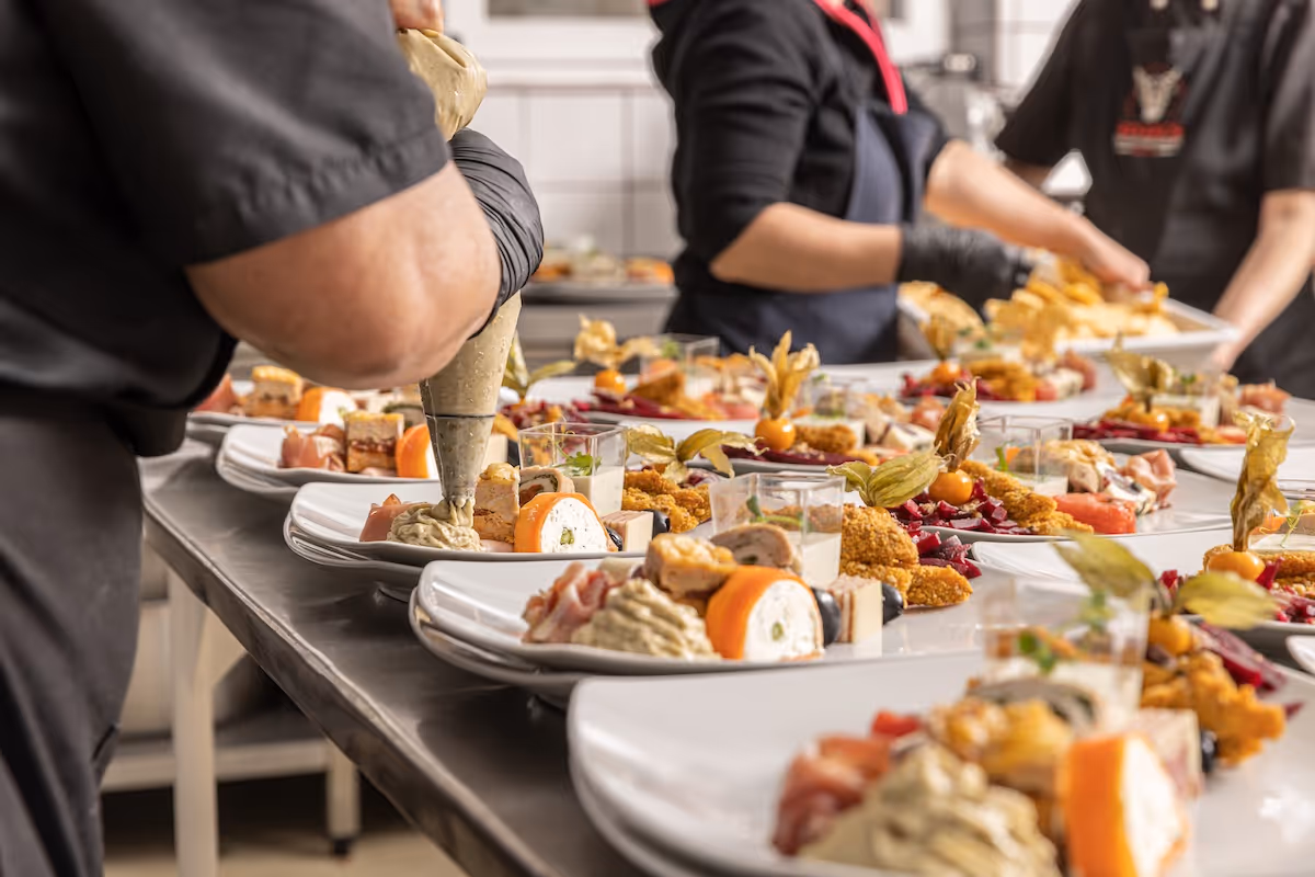 Catering team plating gourmet meals for a large corporate event by Exquisite Delites in Atlanta.