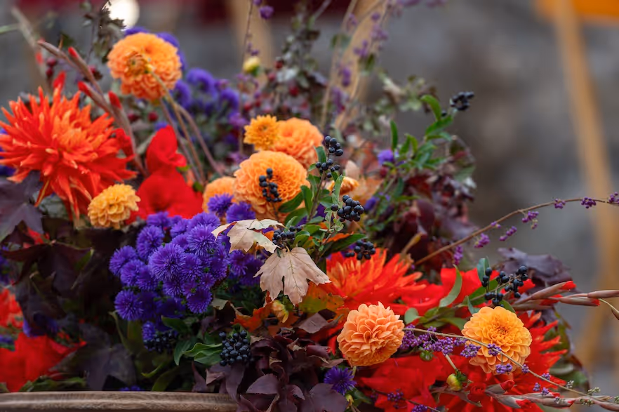 Autumn floral arrangement in orange, purple, and red by Exquisite Delites, Atlanta.