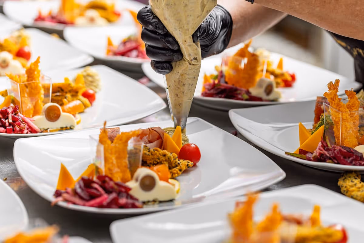 Chef plating gourmet craft service meals with precision for film cast and crew, showcasing Exquisite Delites’ catering expertise in keeping productions on schedule.