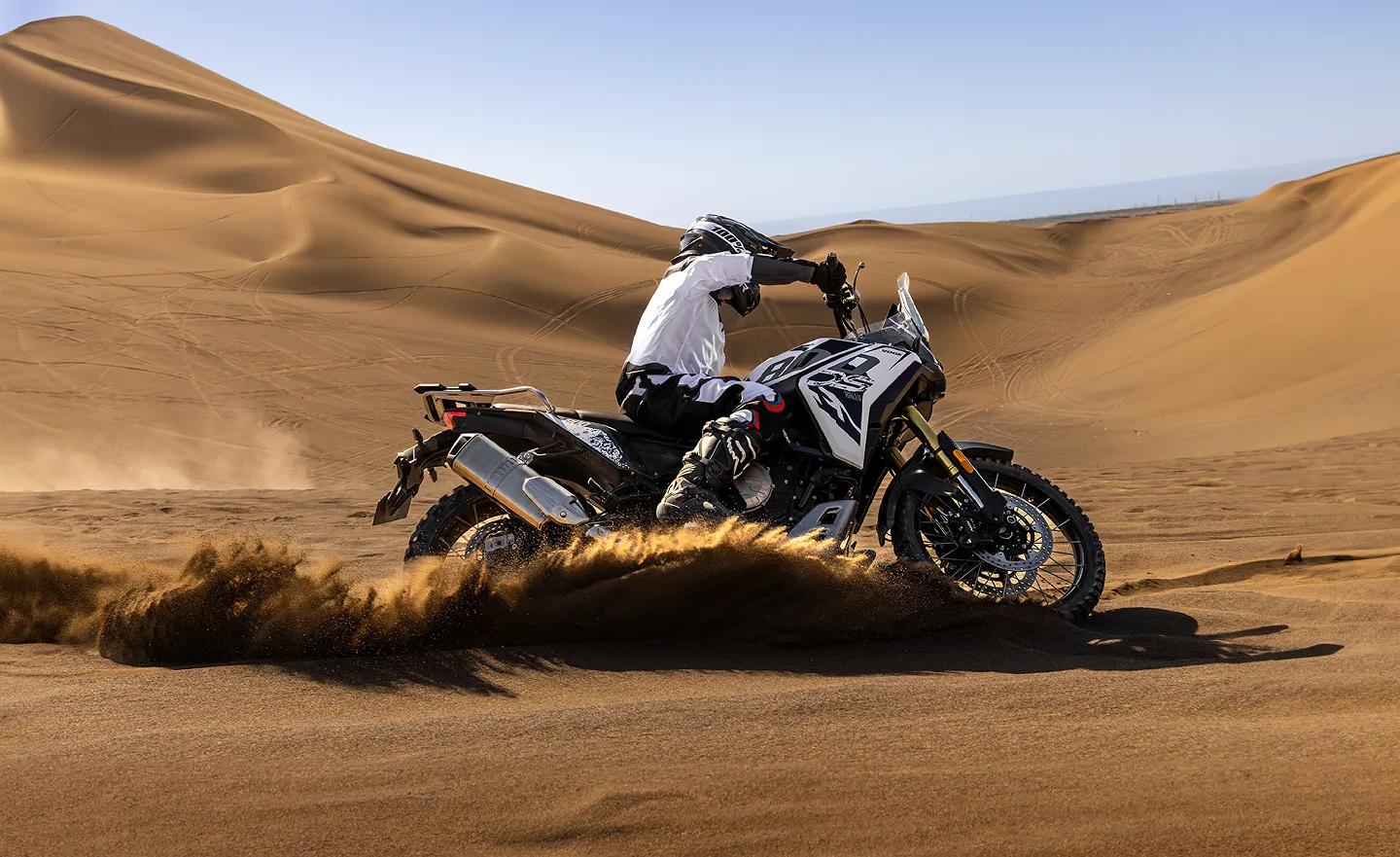 A person riding a motorcycle in the desert.