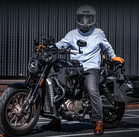 A man sitting on a motorcycle in a parking lot.