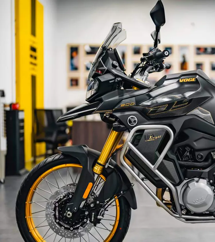 A black and yellow motorcycle parked in a garage.