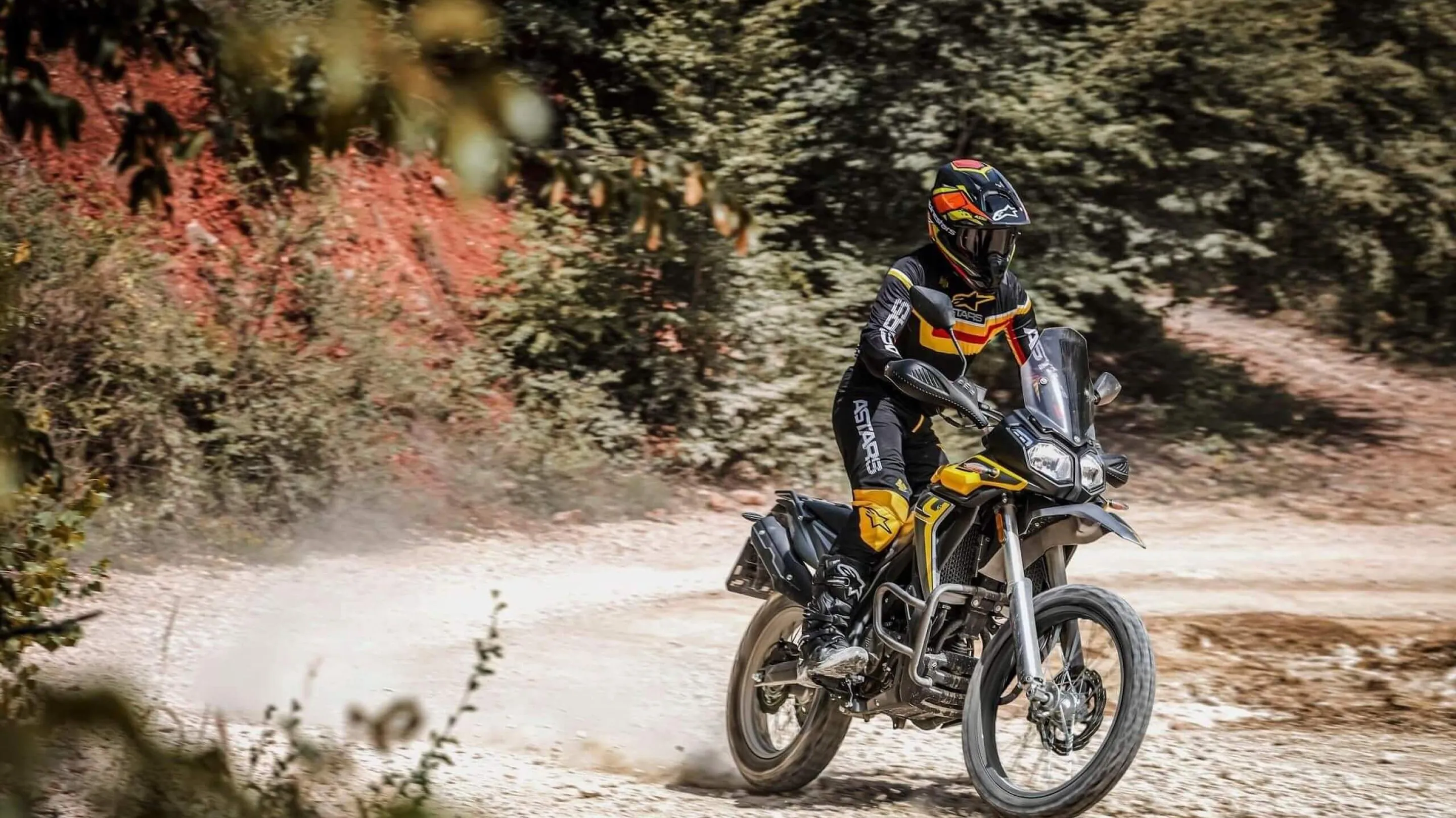 A person riding a motorcycle on a dirt road.