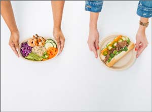 Two people placing their lunch down on a table