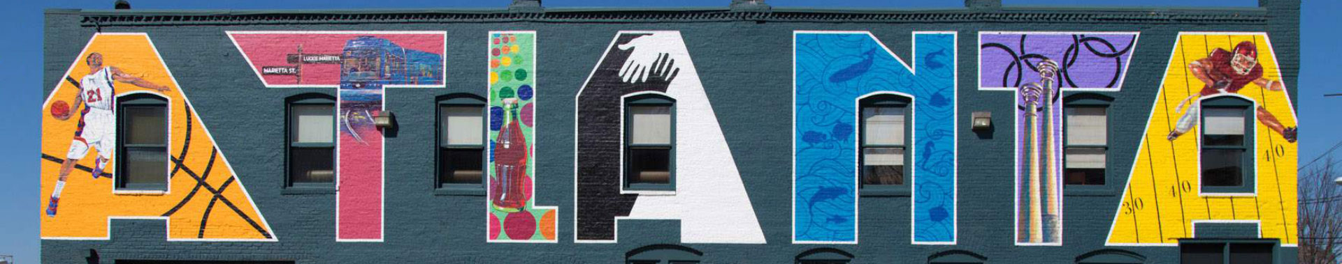 A mural on the side of an apartment building with art in the letters that spell atlanta
