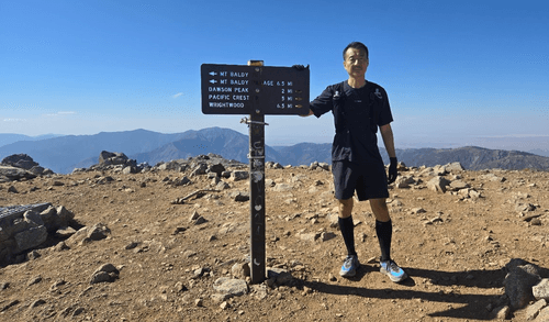 Hiker on Mt. Baldy summit experiencing dizziness during a 15.7-hour fasted hike, illustrating signs of overextension in heat and altitude.