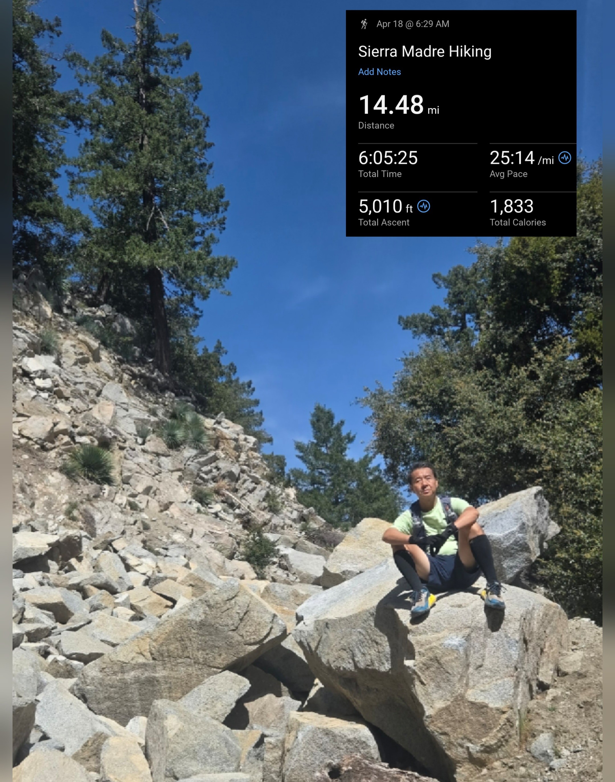 Hiker sits on a boulder on the way to Mount Wilson summit.