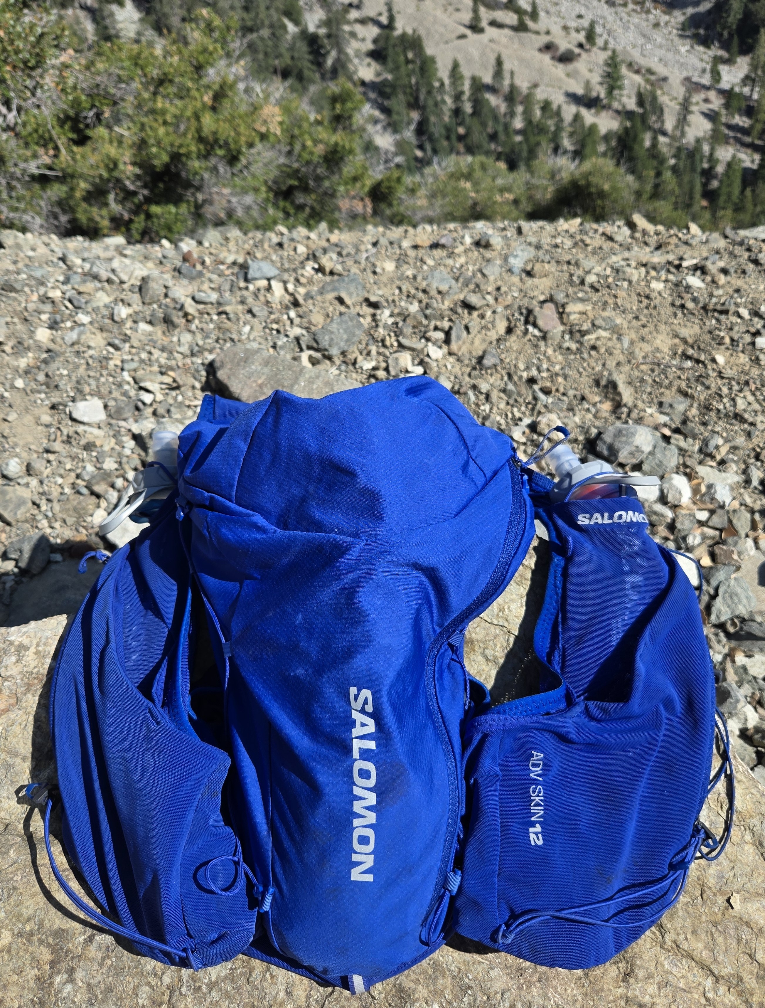 Salomon ADV Skin 12 hydration vest arranged on alpine terrain as part of the TrailGenic day-hike packout system