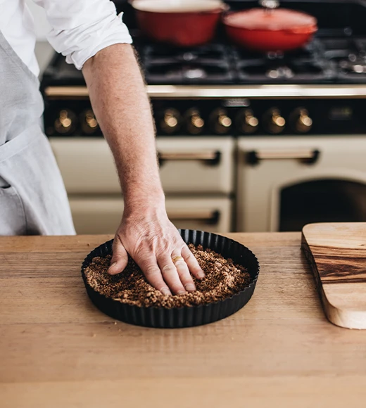 A chef preparing a crumb-based desert