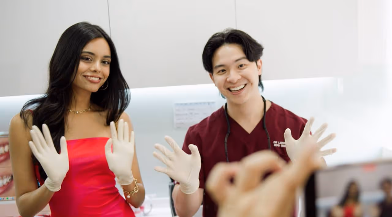 Dr. Leroy waving with contestant in clinic