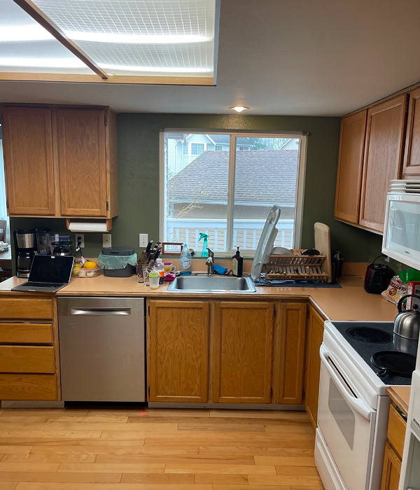  a dated kitchen with oak cabinets, laminate countertops, and fluorescent ceiling lighting
