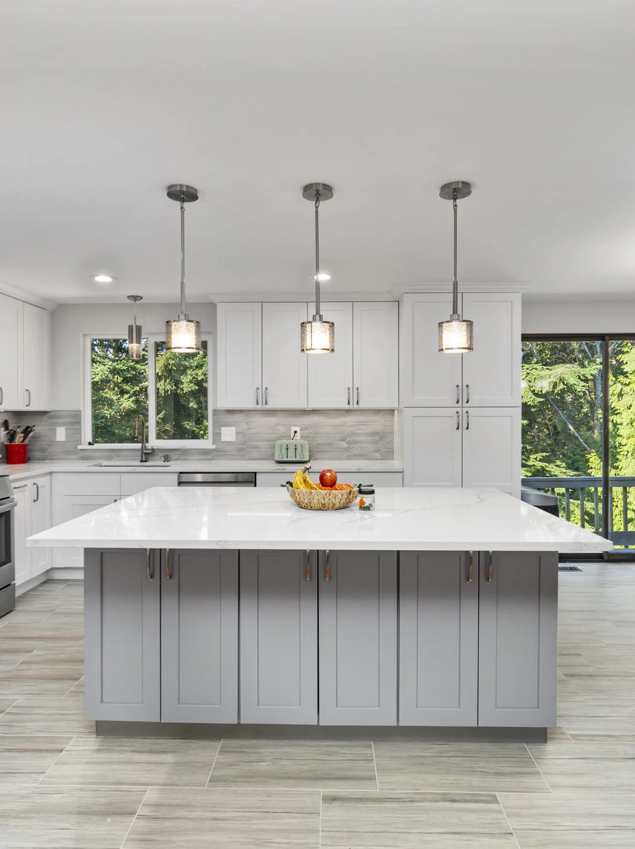Modern kitchen featuring a large light gray island with a white quartz countertop