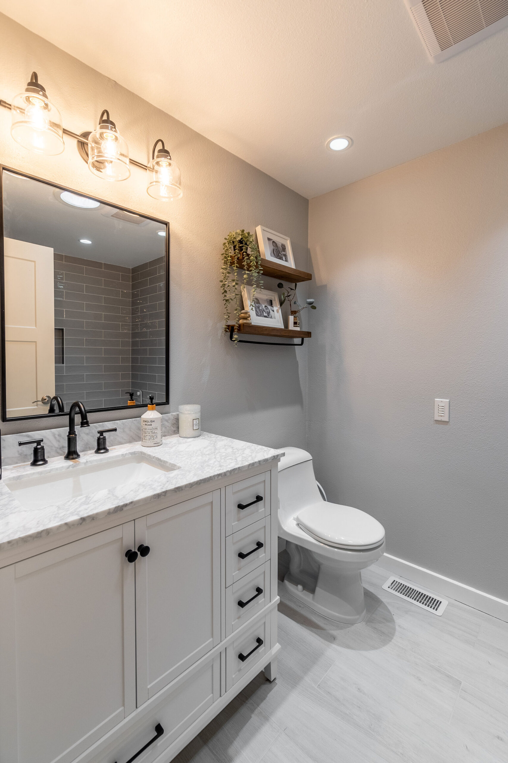 Modern bathroom with a white vanity featuring a marble countertop and matte black fixtures
