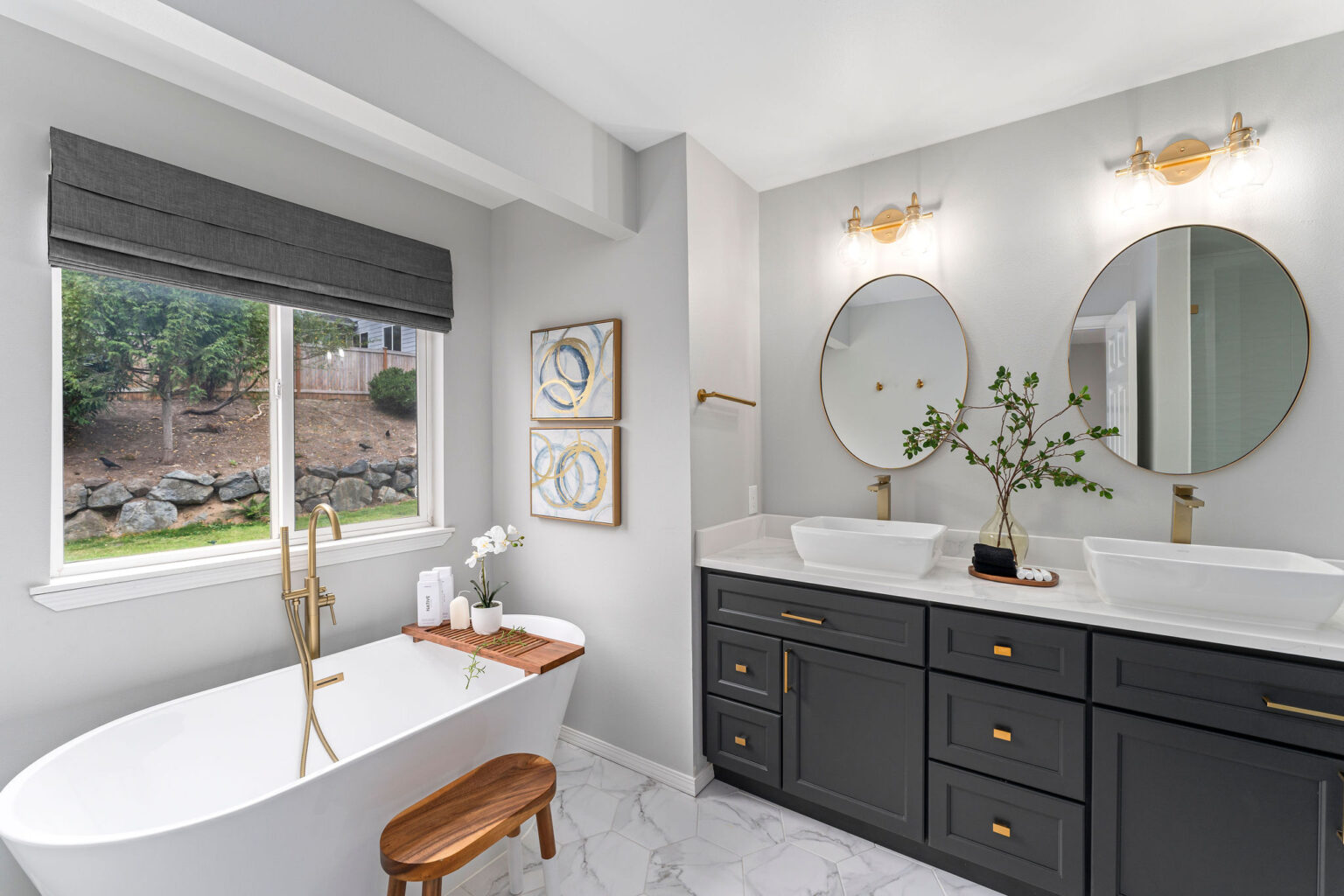 Elegant modern bathroom featuring a freestanding white soaking tub with a wooden bath caddy and matching stool, positioned beneath a large window
