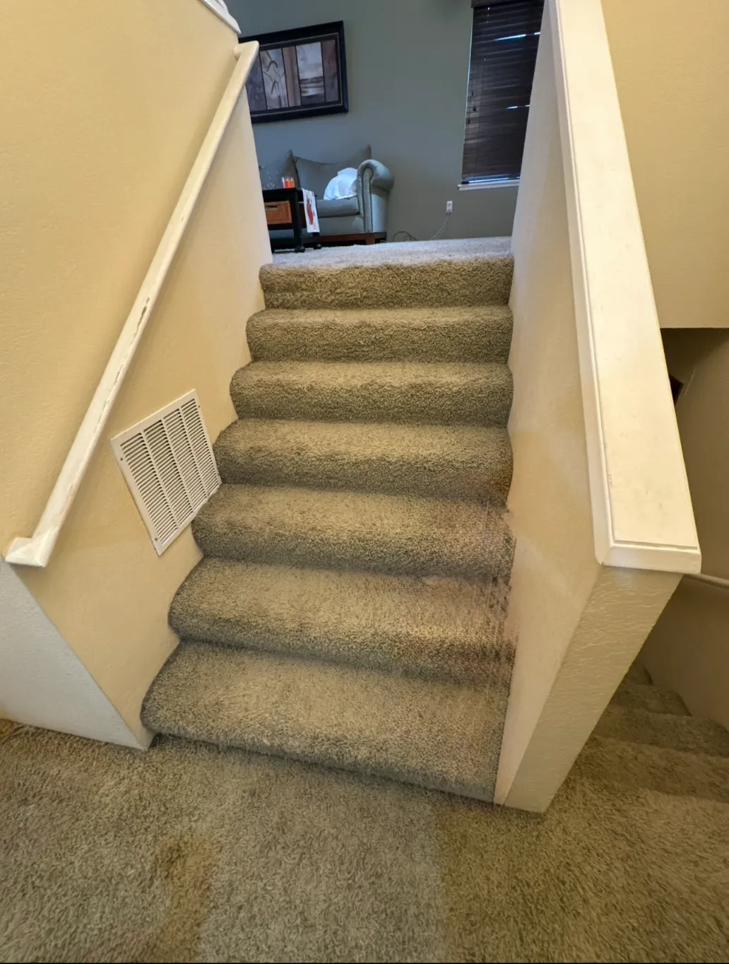Outdated interior stairs in Bellevue home before renovation with worn steps and limited lighting