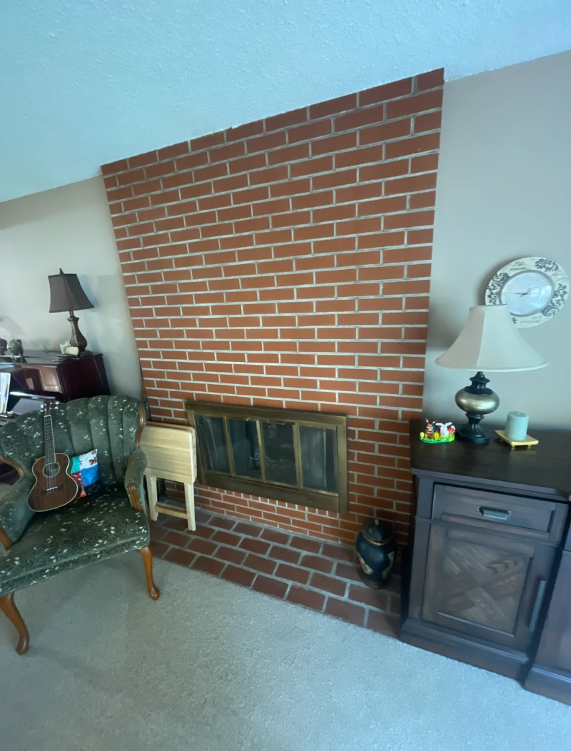 Before remodel of brick fireplace in Bellevue home with dated surround and heavy appearanc