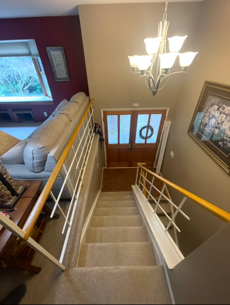 Before remodel of Bellevue home entry stairs with carpeted steps and dated railing