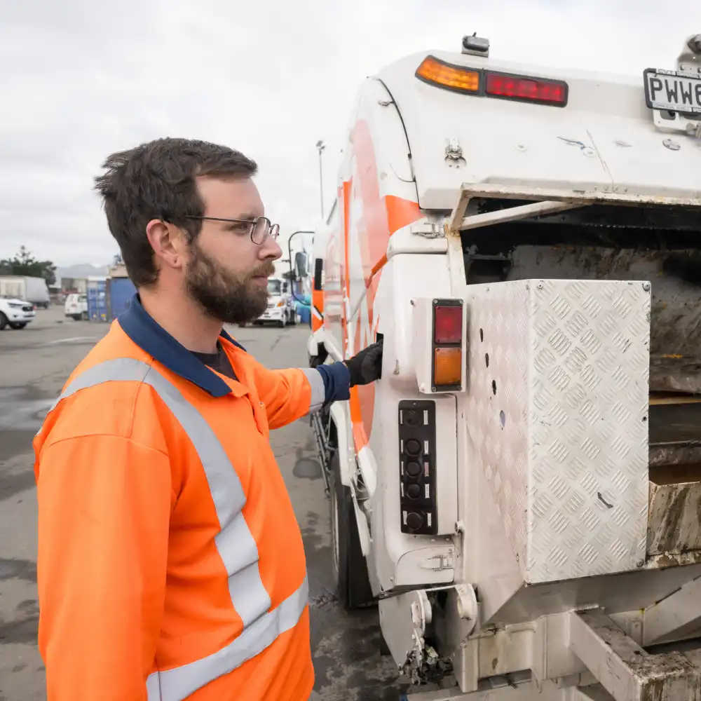 WasteCo team member operating wheelie bin truck