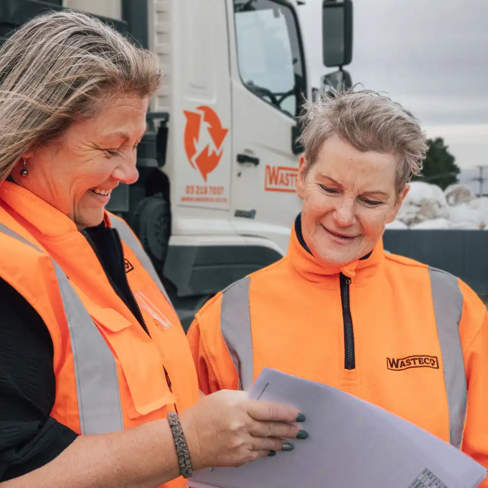 Two WasteCo team members checking a service schedule