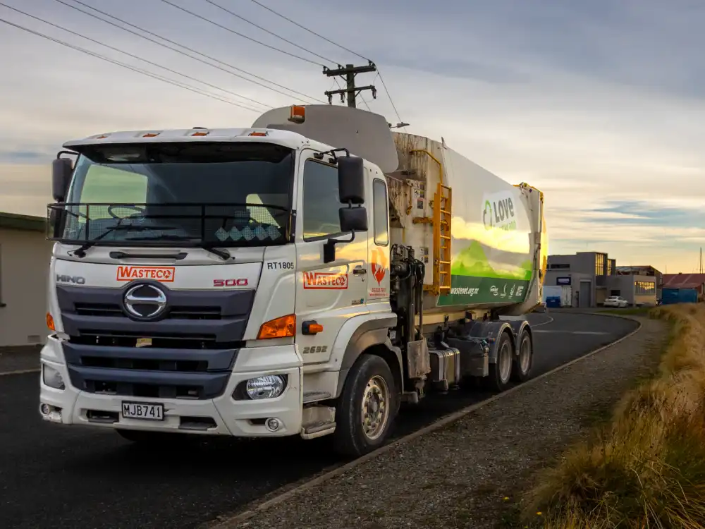 A WasteCo truck parked on the side of the road