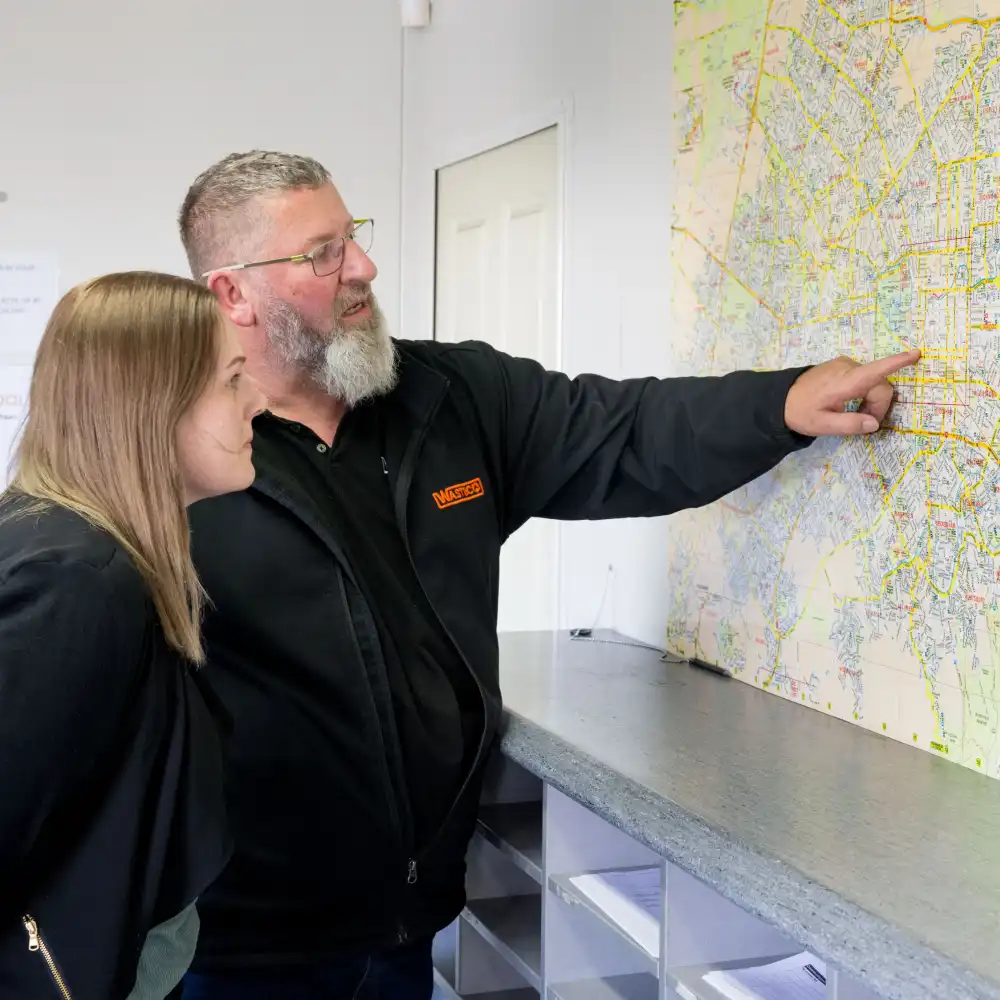 Two WasteCo team members examining a customer map