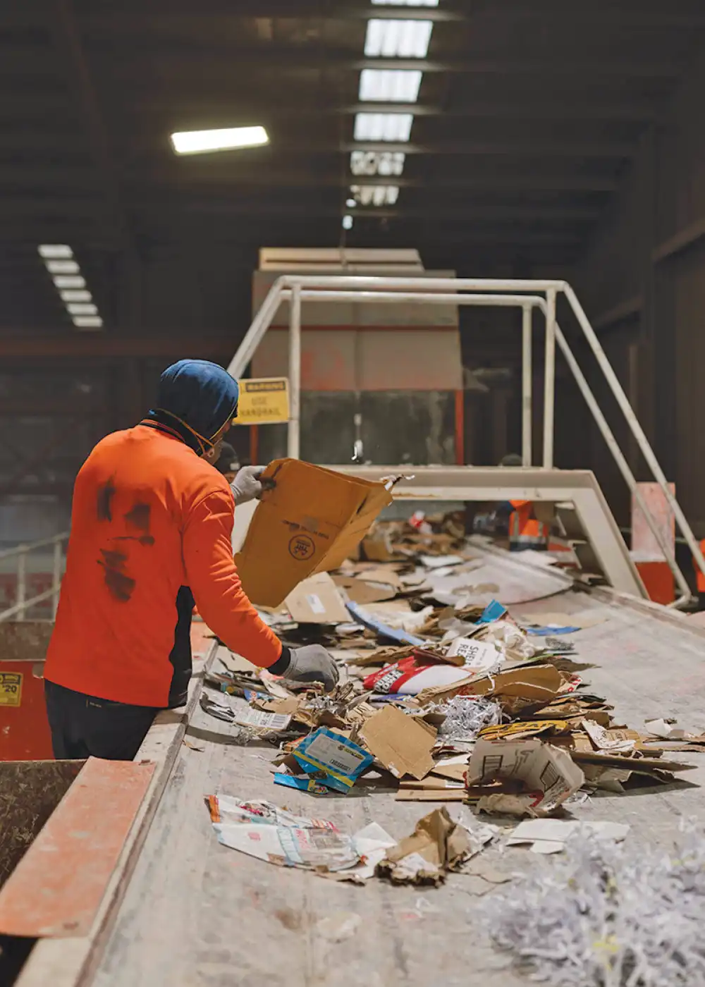 A WasteCo team member sorting paper at the WasteCo sorting facility