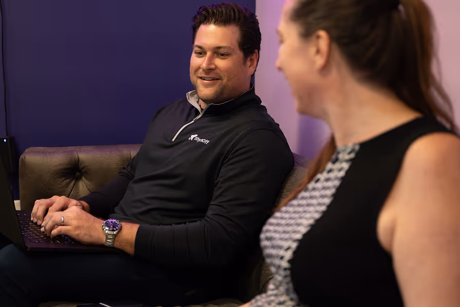 ShyftOff colleagues collaborating on laptop in relaxed office setting