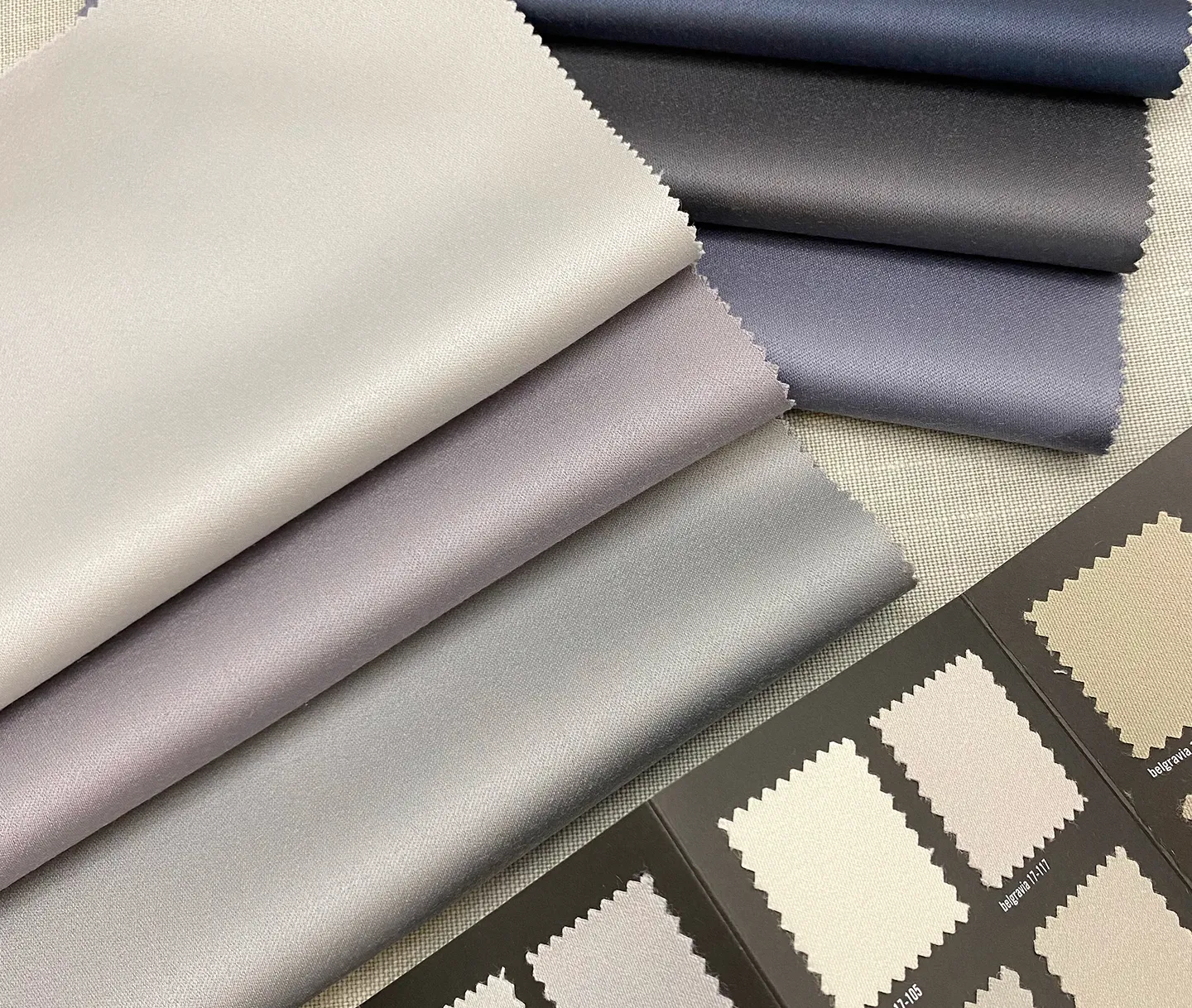 A group of different colours of luxury fabric on a table.
