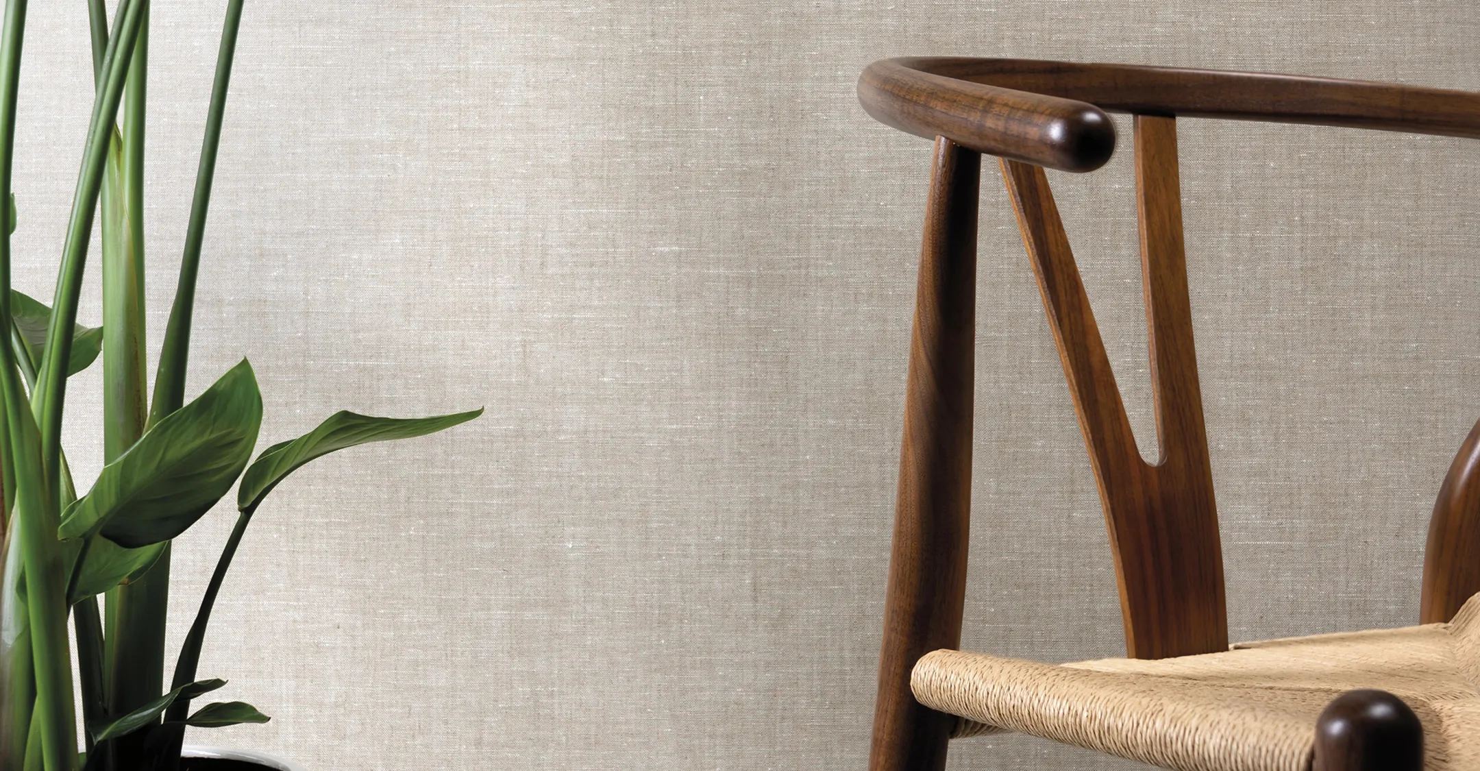 Neutral luxury wallcovering styled in a modern interior with a solid wood chair and greenery.