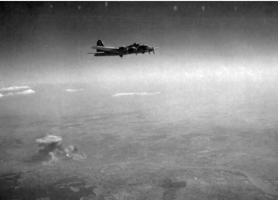 Rákosrendező vasútállomás bombatámadás után füstfelhőben. Visszatérő amerikai B-17 bombázó Budaörs fölött. A felvétel 1944. szeptember 17-én készült. (Fortepan/National Archives)
