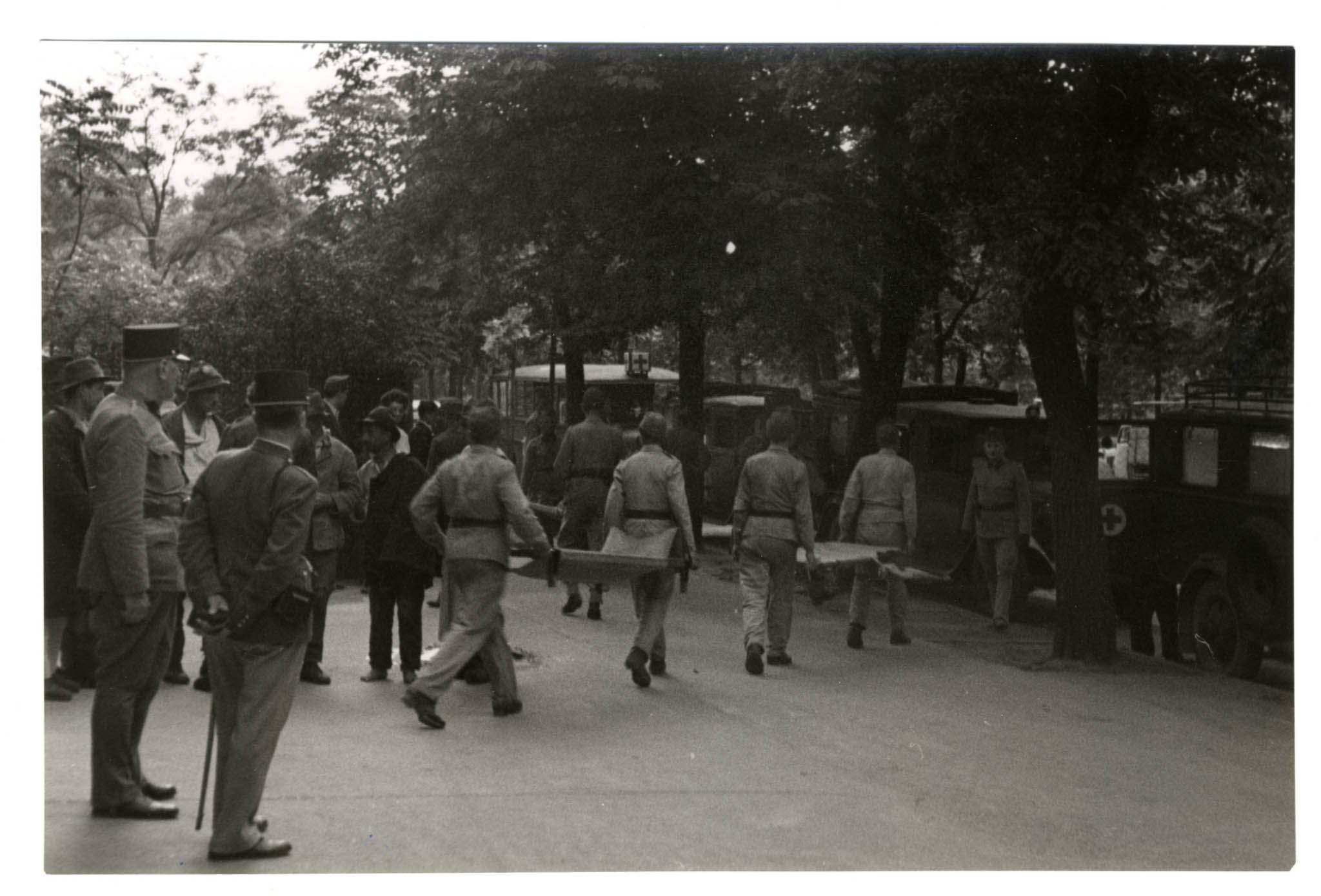 Mentési munkálatok a bombázás után. Hordágyakkal mennek a vöröskeresztes autók felé (MNM)