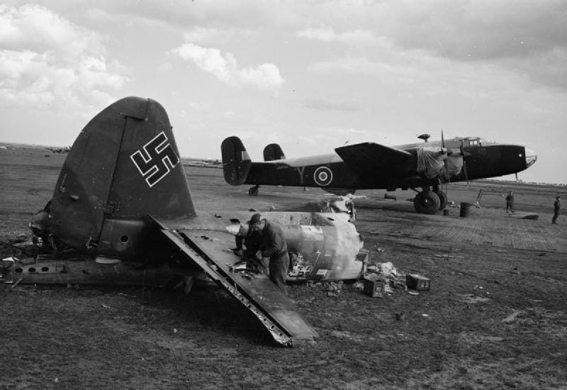 A brit 614. bombázószázad Halifax II négymotoros nehézbombázója Celone repülőtéren. Az előtérben egy német Ju-88-as gép roncsát használják munkapadként. (Wikimedia Commons)