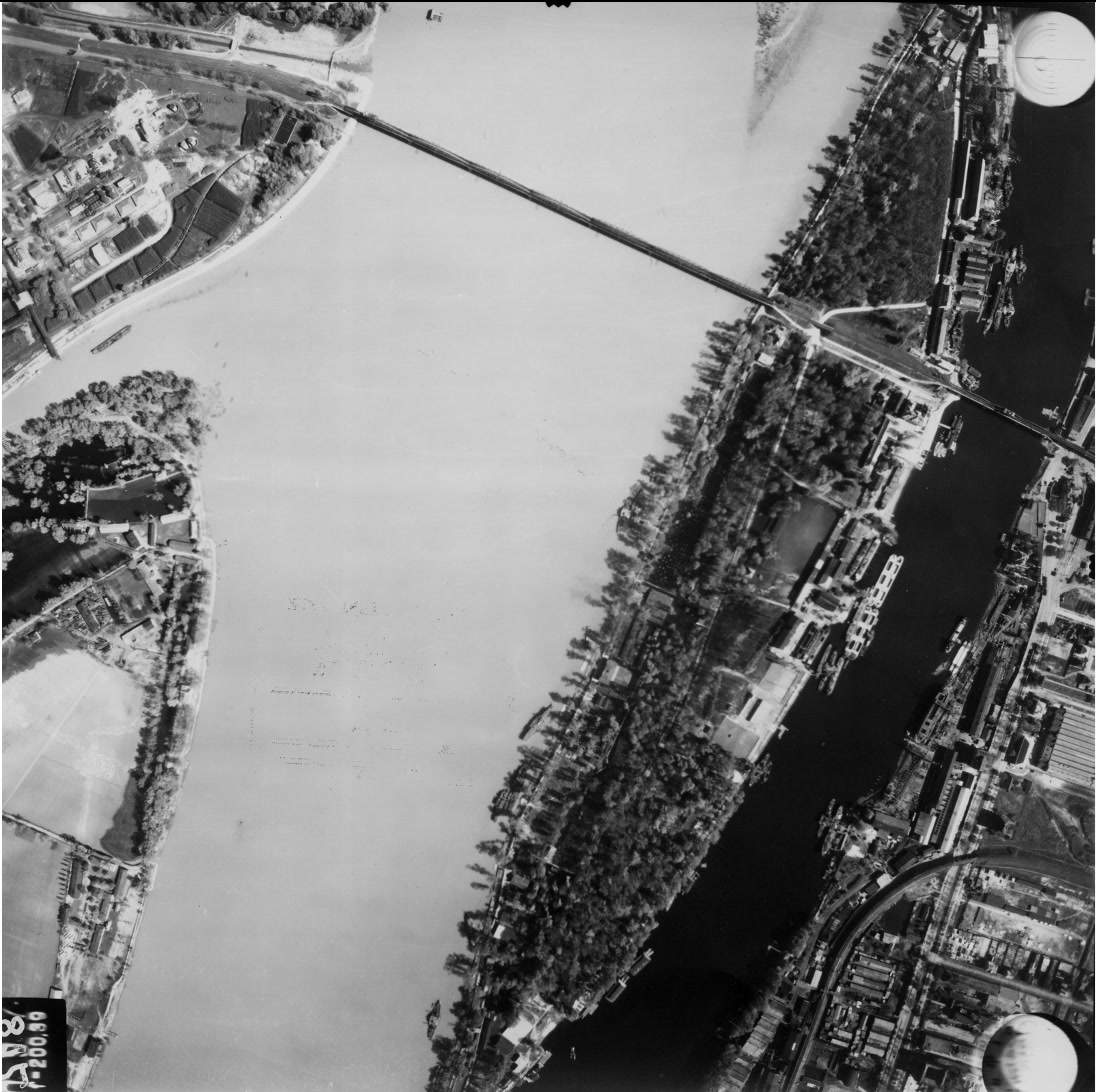 Légifotó. Balra a Hajógyári-sziget északi csúcsa, jobbra a Népsziget és az Újpesti-öböl látszik, keresztben az Újpesti vasúti híd halad. Fenn a Palotai-sziget déli csúcsa van a képen. A budai parton a Gázgyár épületei vannak. A felvétel 1944. április 14-én készült. (Fortepan/Magyar Királyi Honvéd Légierő)